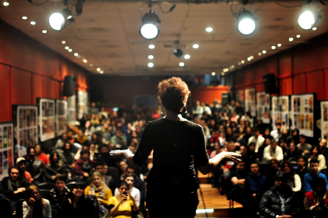 An individual on stage giving a presentation