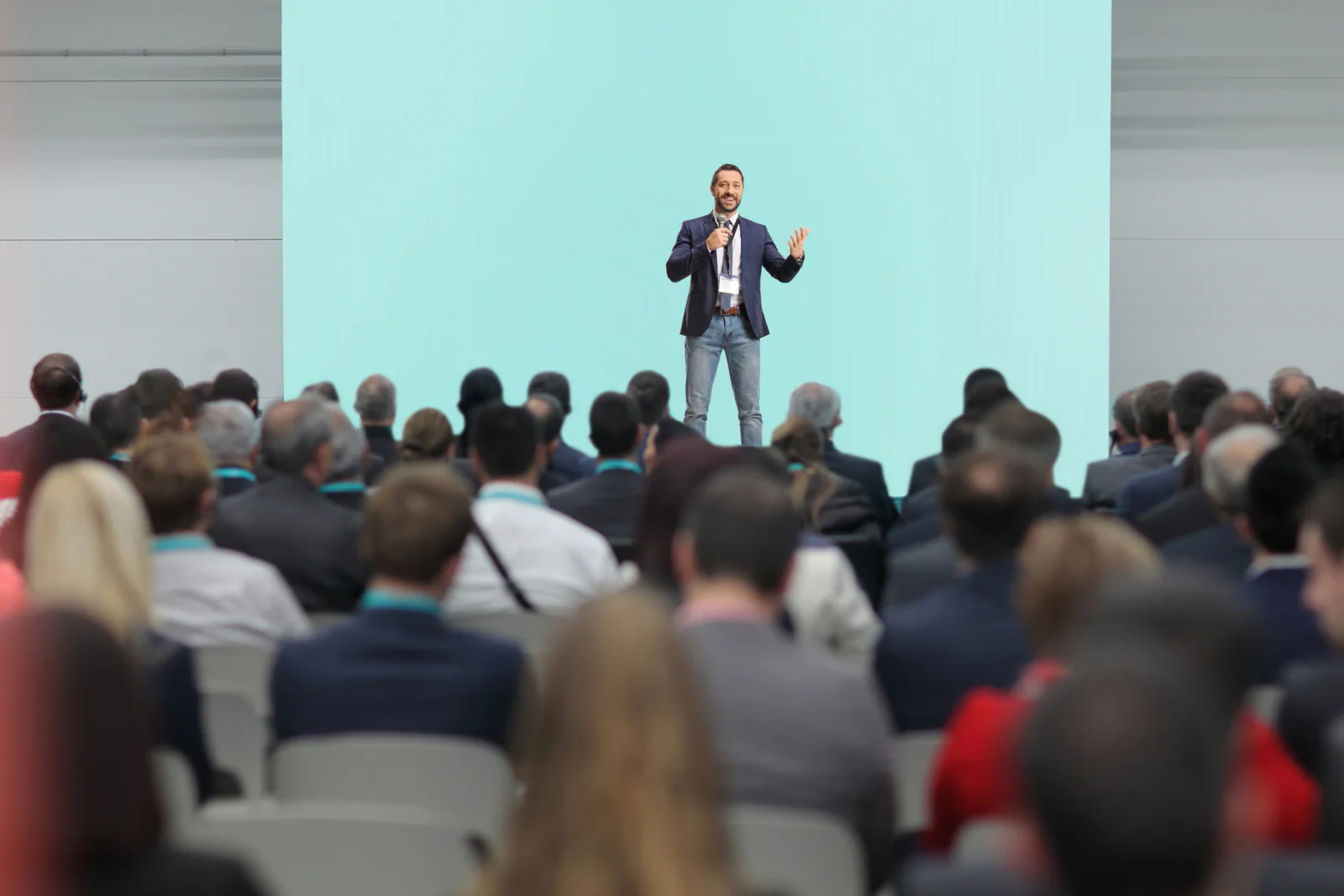 Corporate conference speaker addressing a seated audience during a professional business event
