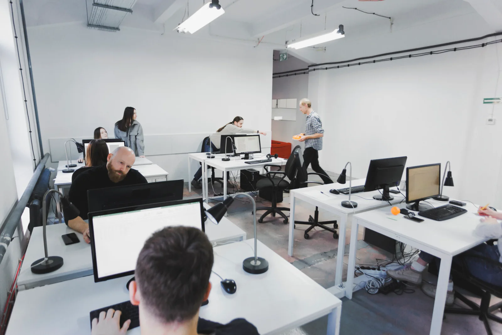 Temporary office team using laptops, headsets, and cloud communication tools in a pop-up business workspace
