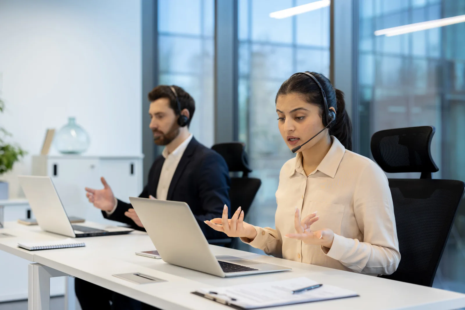 Operations team coordinating communication continuity during an office transition with laptops, headsets, and cloud collaboration tools